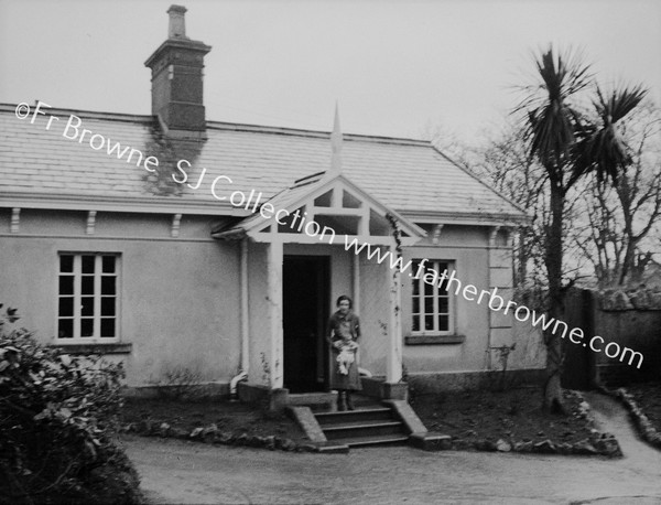 MOTHER AND CHILD AT DOORWAY OF BUNGALOW